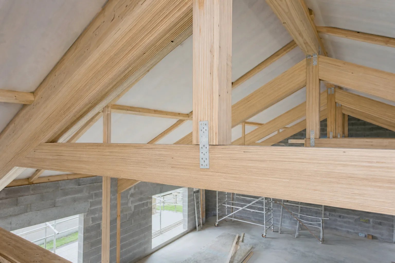 Structure de charpente en bois lamellé-collé montée en ferme sur un chantier en cours